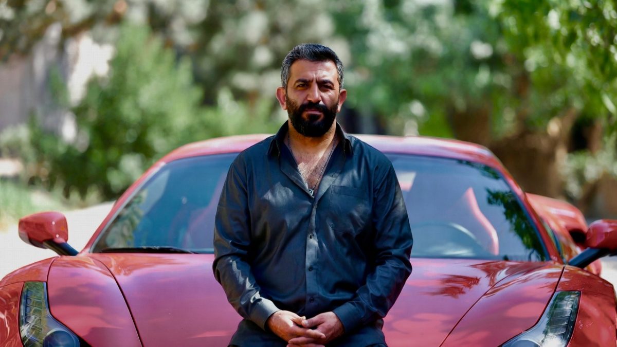- https://blowthetruth.com/wp-content/uploads/2026/07/Tobacco-Store-fire-Bomb-1.jpeg tobacco kingpin Kazem ‘Kaz’ Hamad in Iraq sitting on a sports car