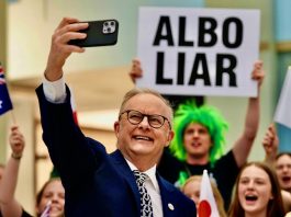 PM Anthony Albanese with a person green hair holding a sign Albo Liar